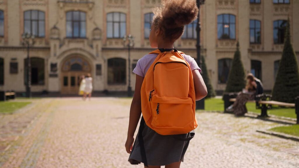 Child with backpack walks away